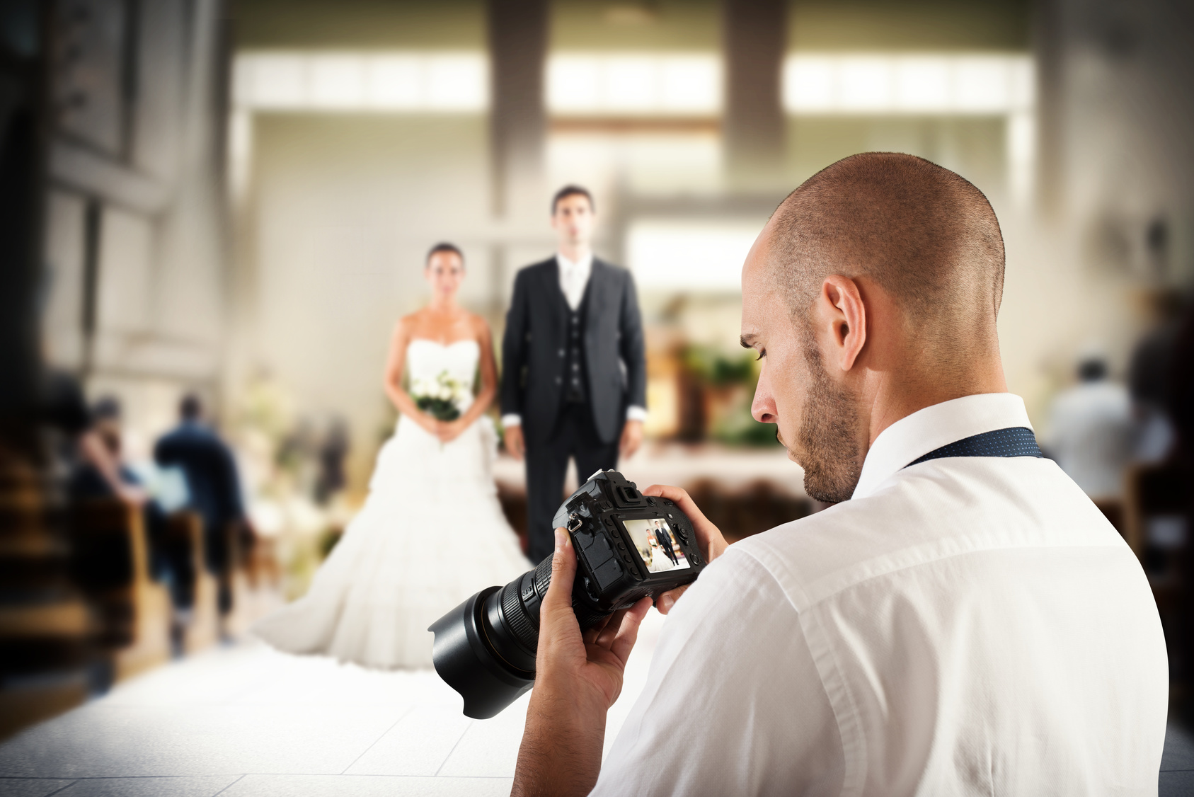 Photographer looks at the screen of camera to a wedding